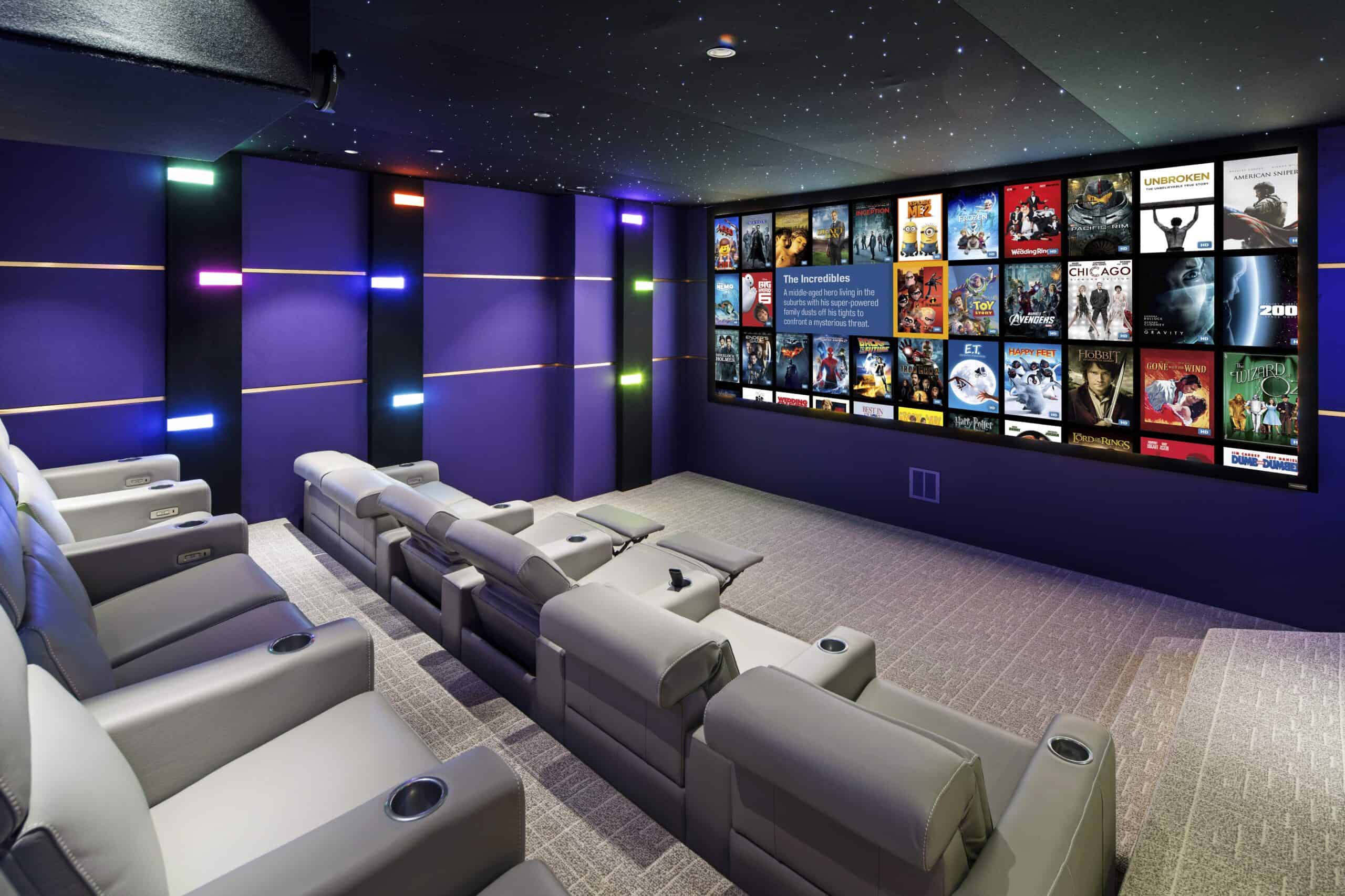 Modern home theater room featuring plush seating and a large screen displaying various movies.