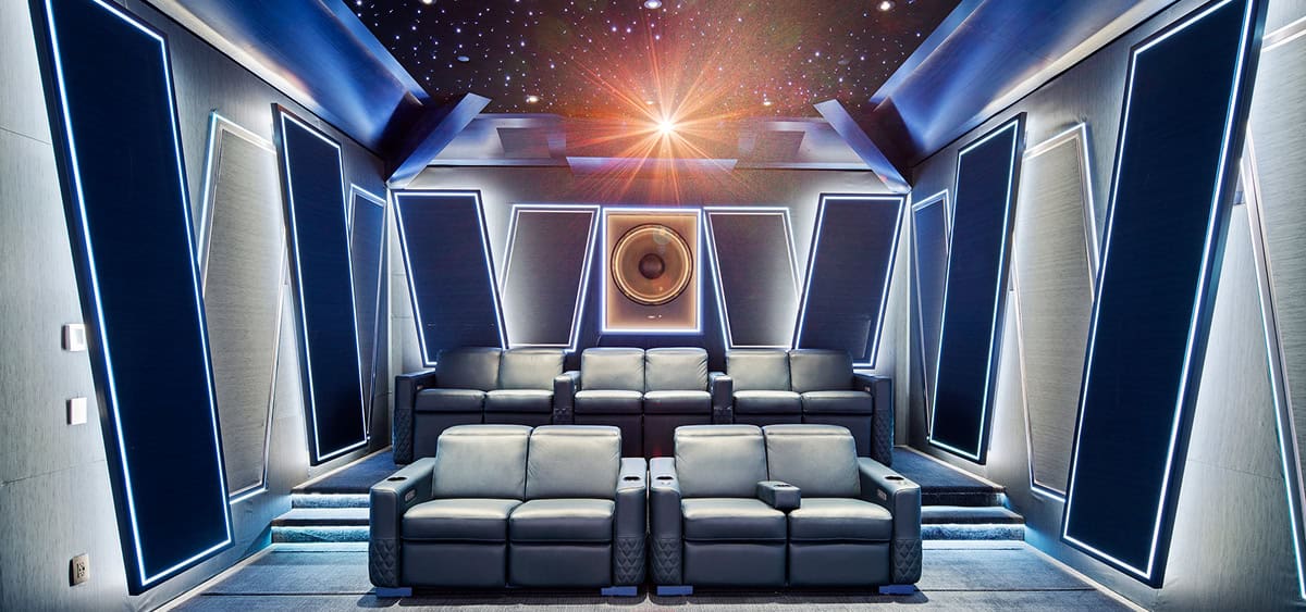 Beautifully designed home theater room featuring acoustic panels, plush seating, and starry ceiling projection.