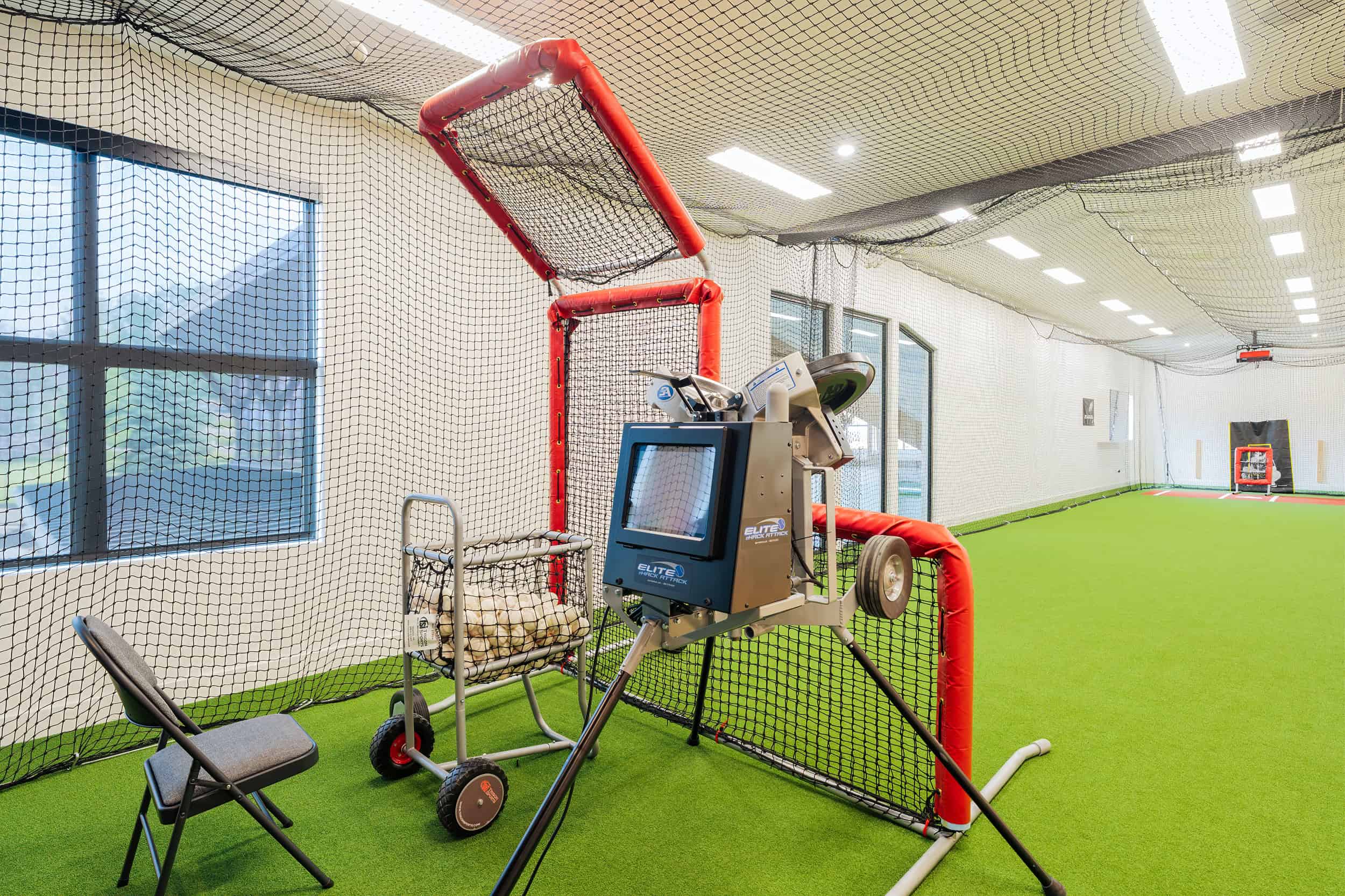 State of the art indoor home pitching machine and safety nets for batting practice.