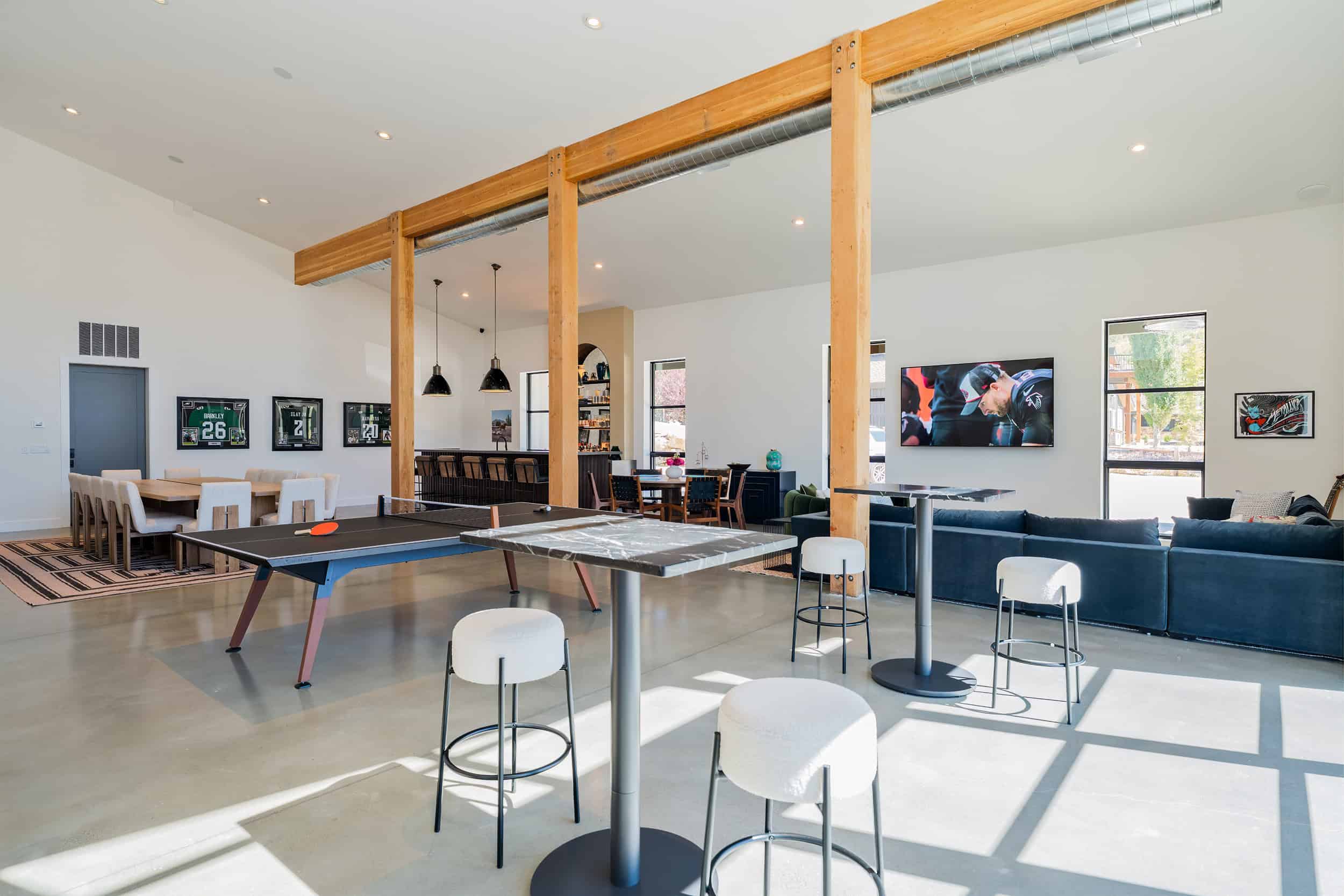 Modern luxury game room featuring ping pong, bar, and TV entertainment.