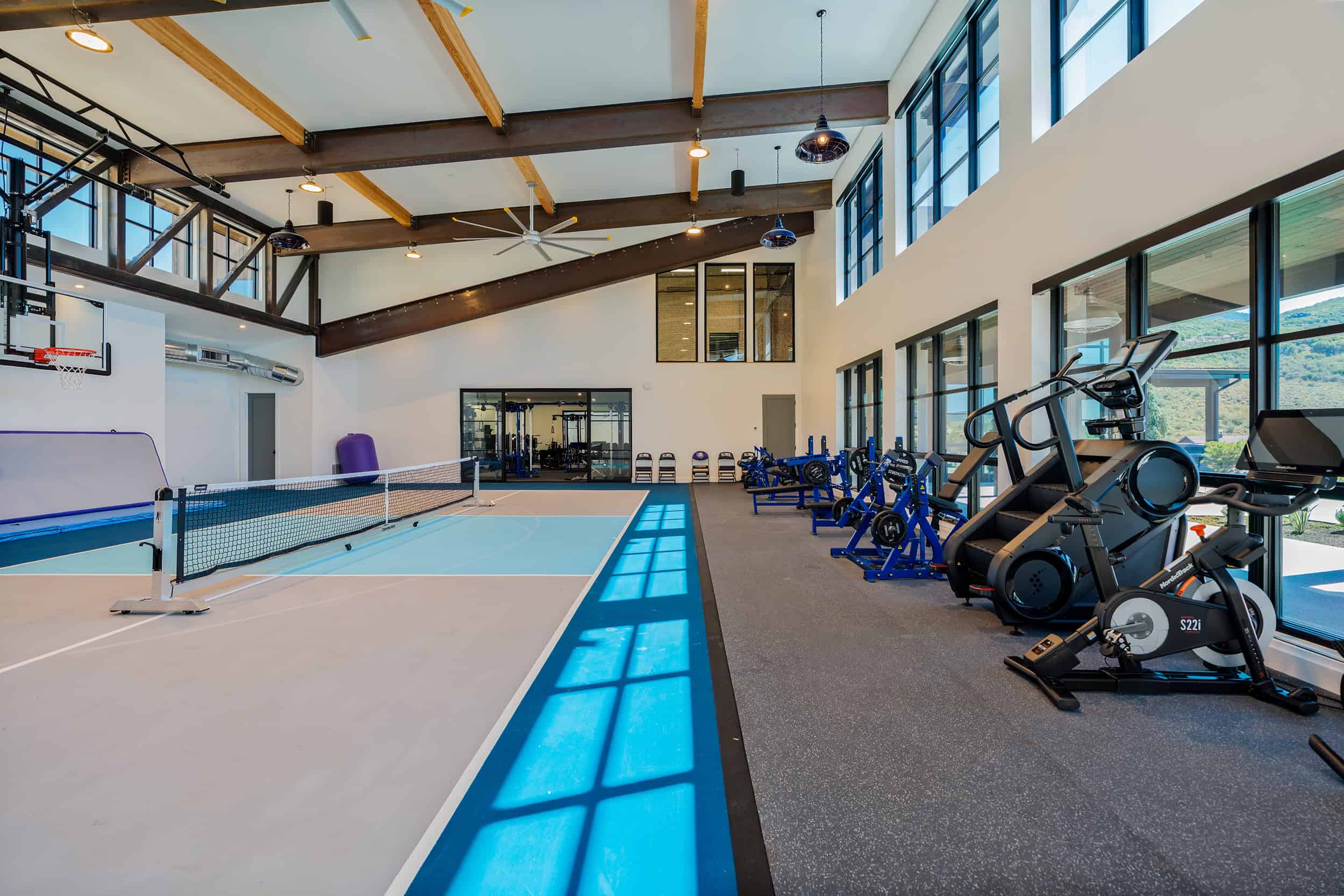 Bright, spacious home workout area with large windows and various exercise machines in Park City