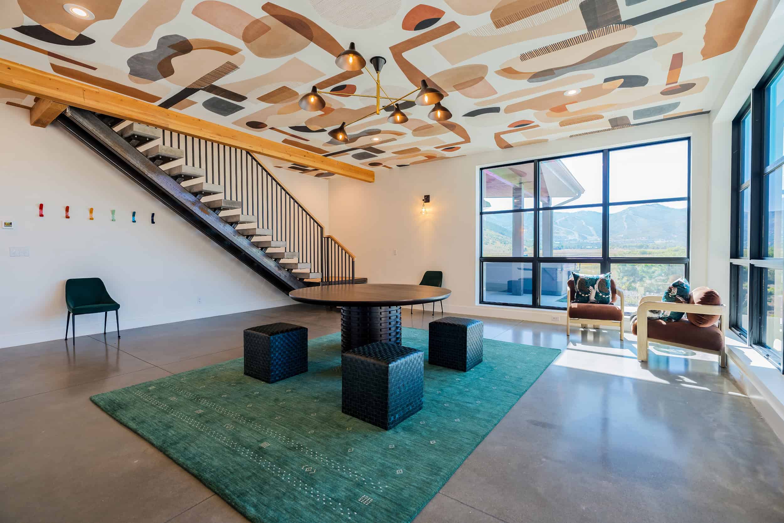Bright sitting room with artistic ceiling design, large windows for natural light, and modern furnishings.