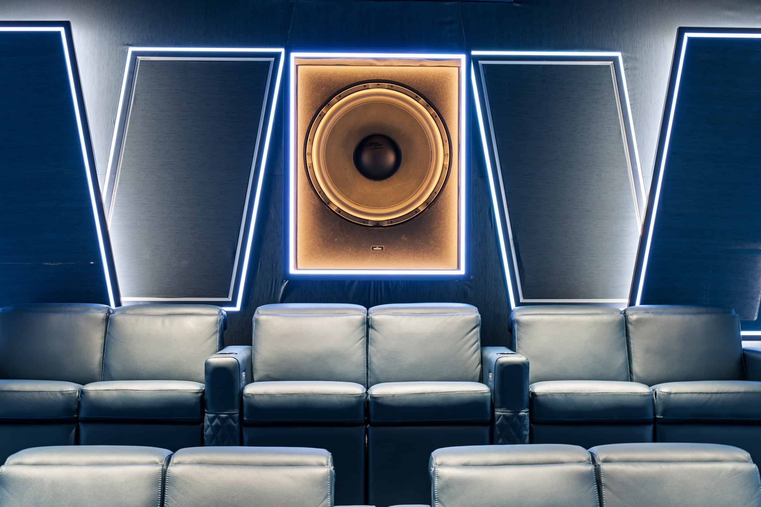Sleek theater featuring contemporary soundproofing panels, comfortable leather seats, and impressive audio equipment for optimal sound experience.